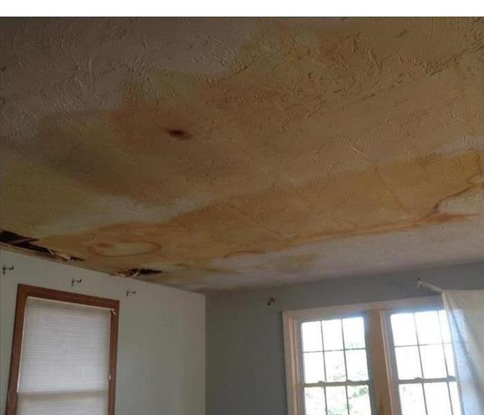 Water damaged ceiling showing dark staining to drywall