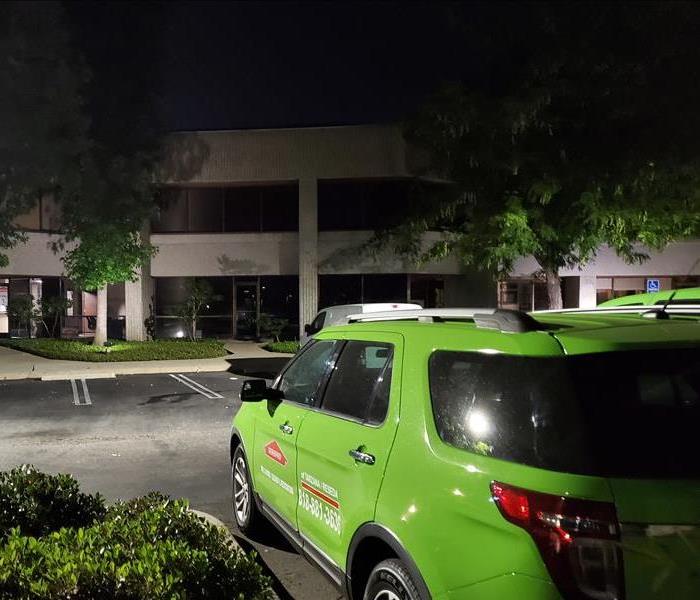 SERVPRO's green vehicle at night in front of commercial building